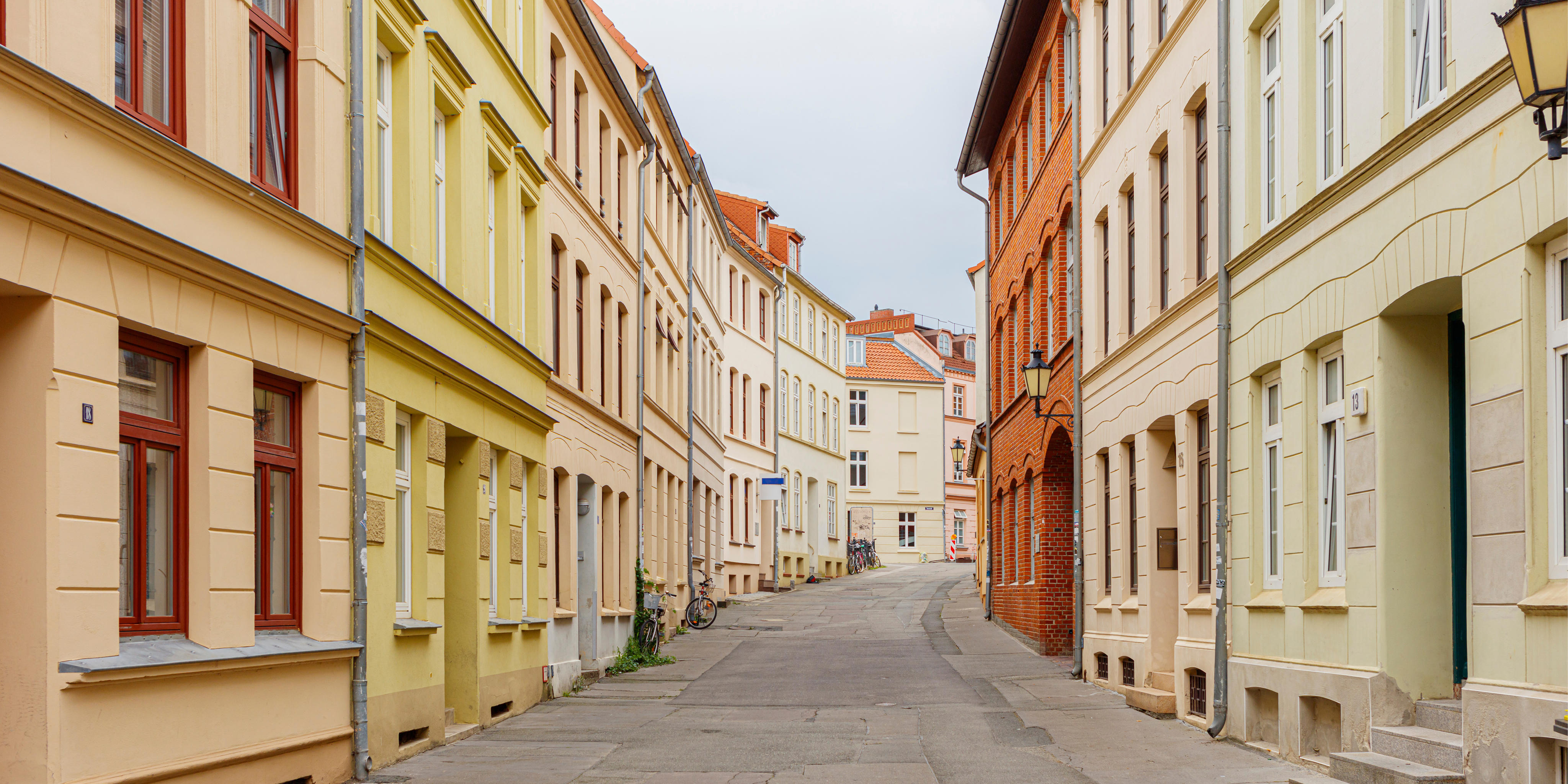 Straßenzug mit historischen, denkmalgeschützten Altbaufassaden in unterschiedlichen Farben
